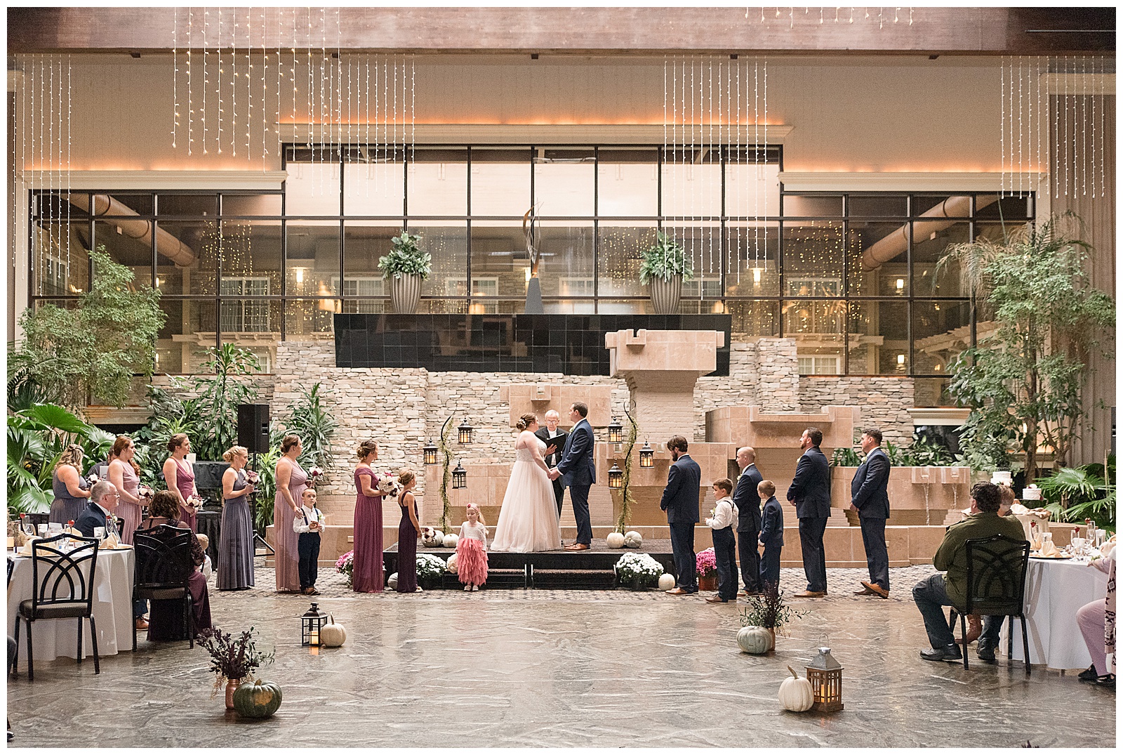 bride and groom holding hands surrounded by bridal party during wedding ceremony inside eden resort courtyard