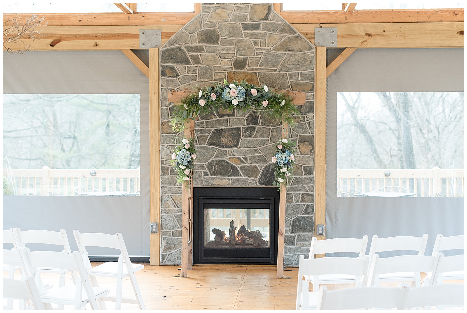 beautiful stone fireplace outlined in natural wood with floral garland at riverdale manor