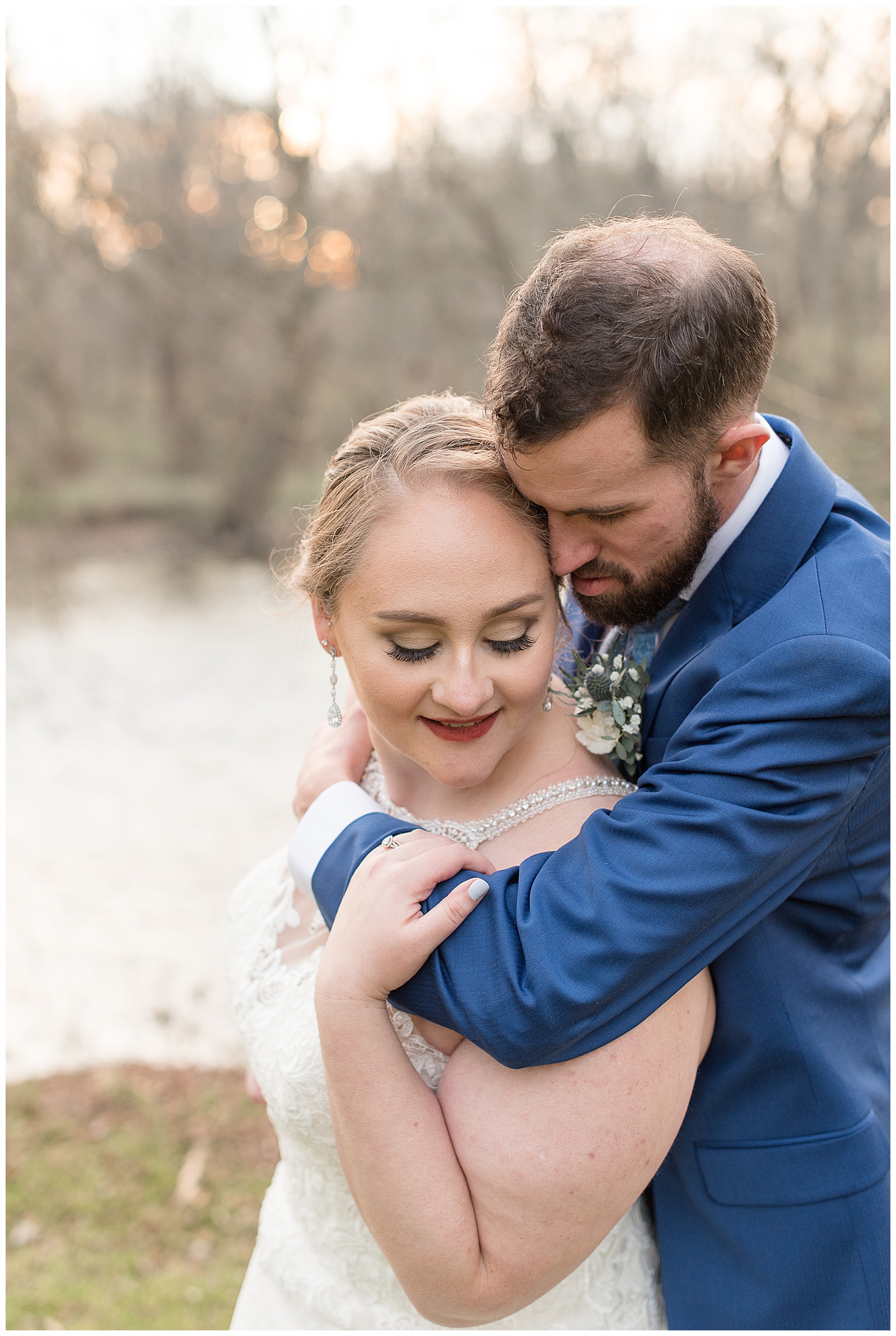groom hugs bride as they look down and smile and embrace in lancaster pennsylvania