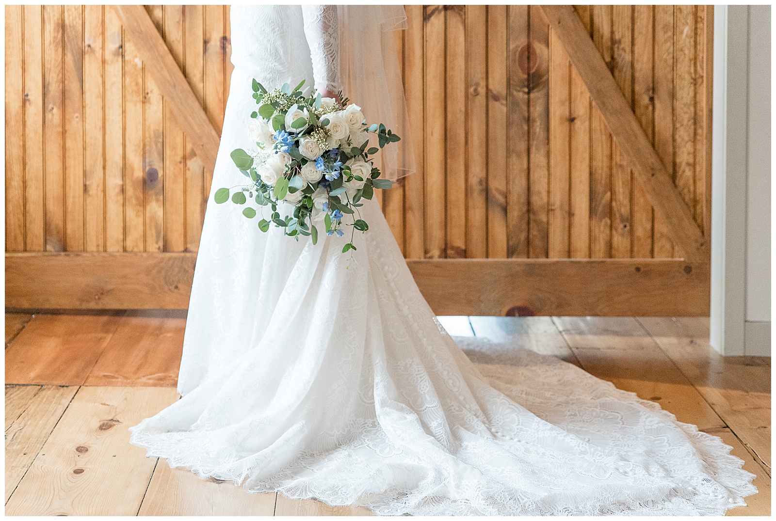 bridal gown train and bride's bouquet by wooden barn door at mill at manor falls