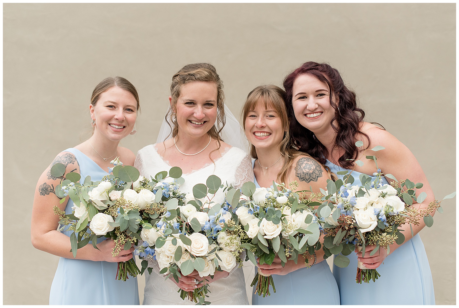 bride and bridesmaids smiling holding light blue and white bouquets in lancaster pennsylvania