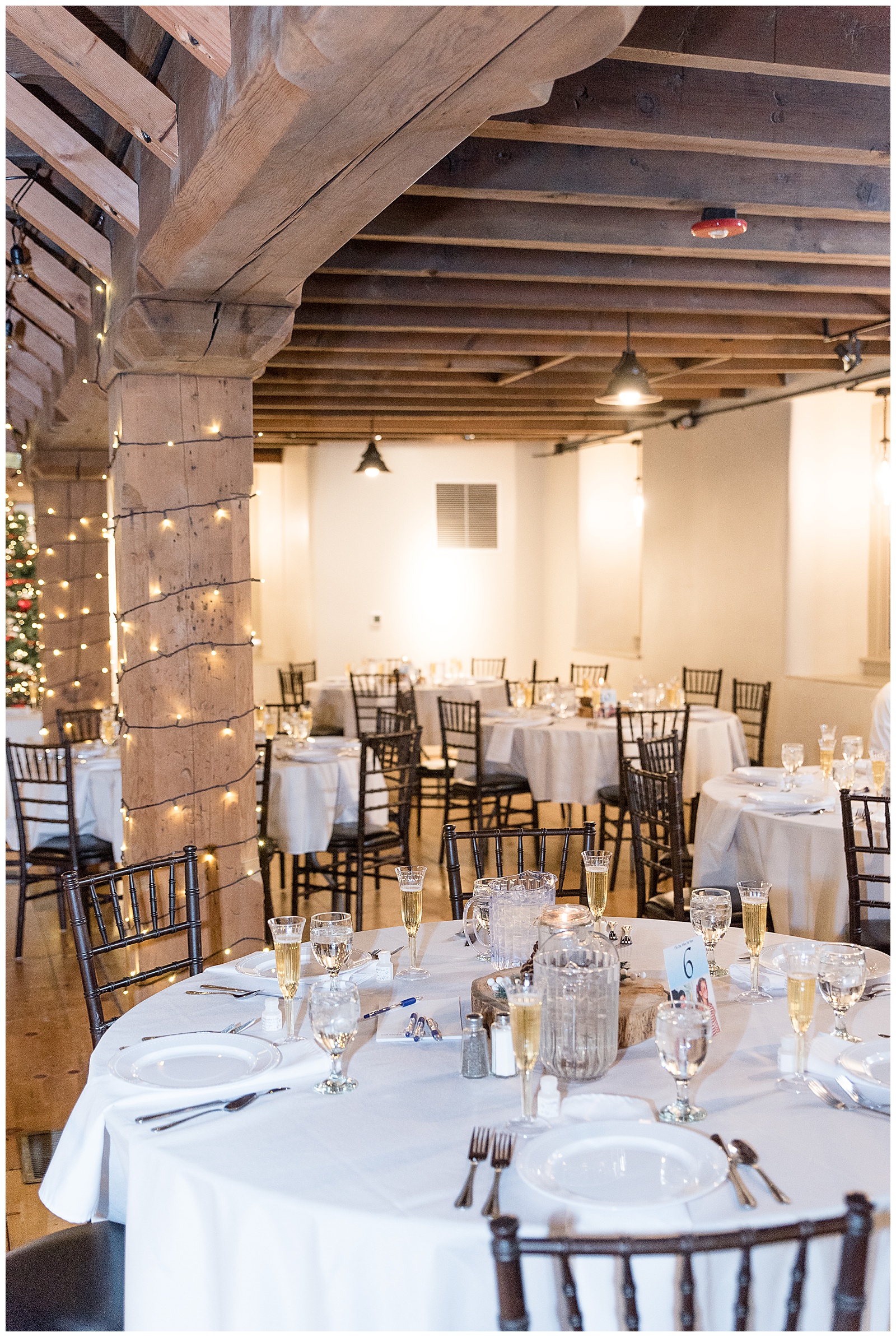 beautiful rustic barn reception area with exposed wooden beams and decorative lights at the mill at manor falls