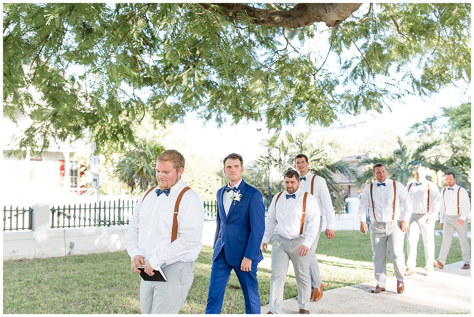 groom and groomsmen entering outdoor ceremony walking down path in key west florida