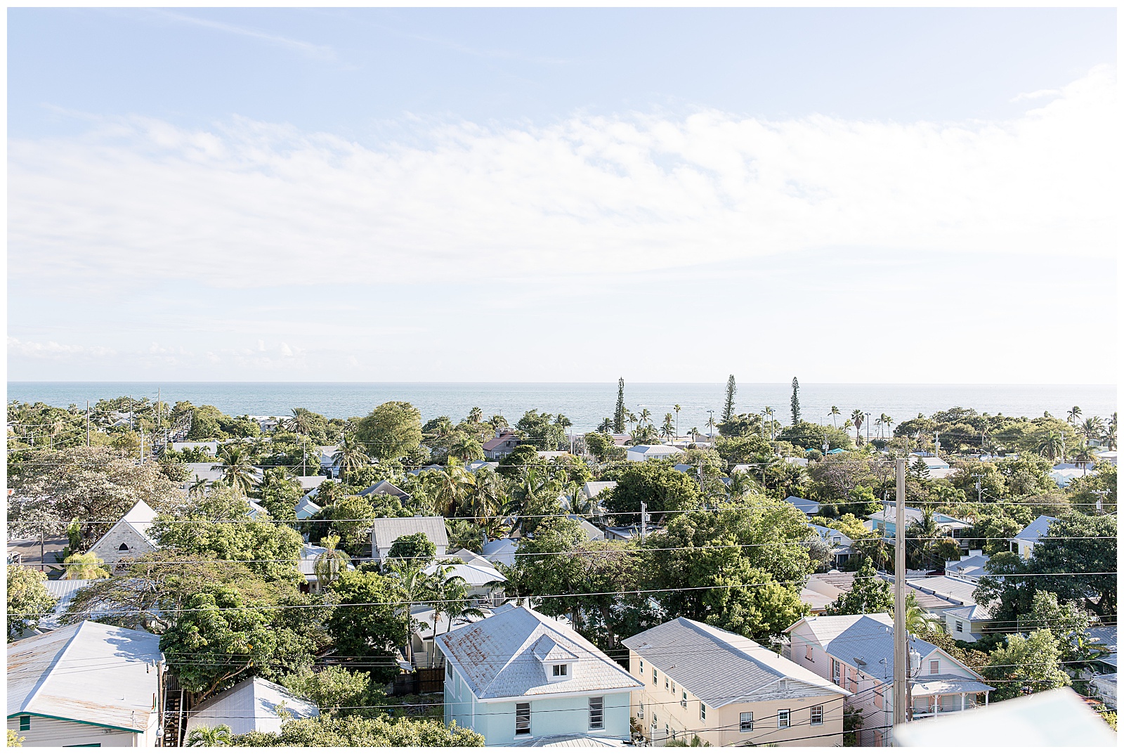 photo from the top of lighthouse with trees and homes below and sky and ocean in the distance at hemingway house