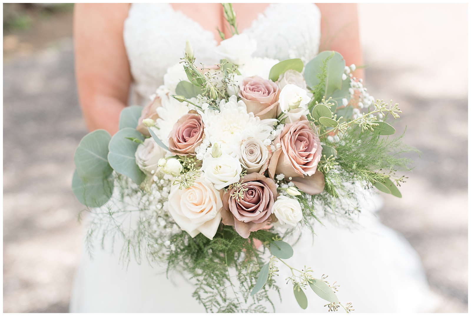 close up of bride holding gorgeous bouquet of mauve roses, white flowers, and eucalyptus