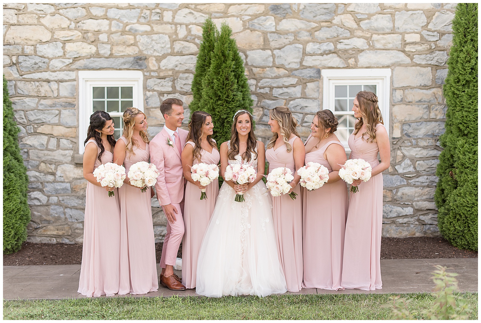 bride with six bridesmaids and one bridesman all wearing light pink at the barn at silverstone in lancaster pennsylvania