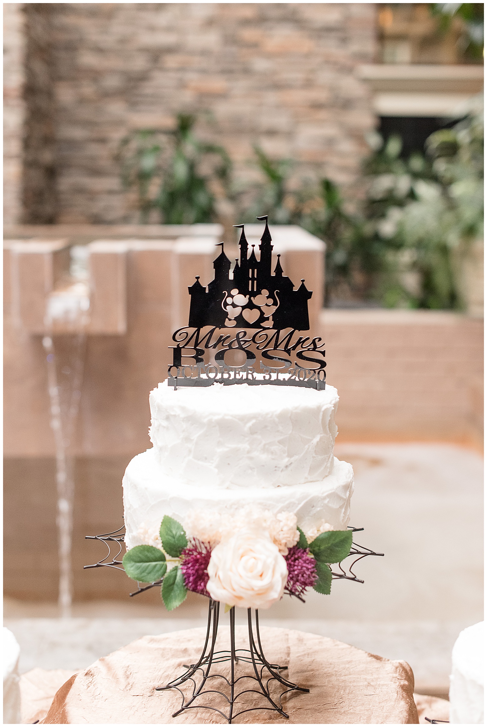 disney themed cake topper displayed on tiered wedding cake with flowers at the eden resort