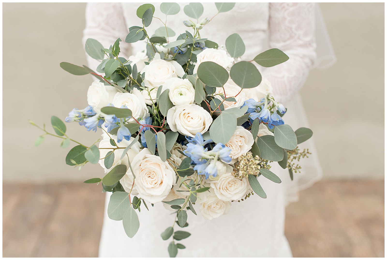 close up photo of bride's bouquet filled with silver dollar eucalyptus, white flowers and roses, and light blue flowers