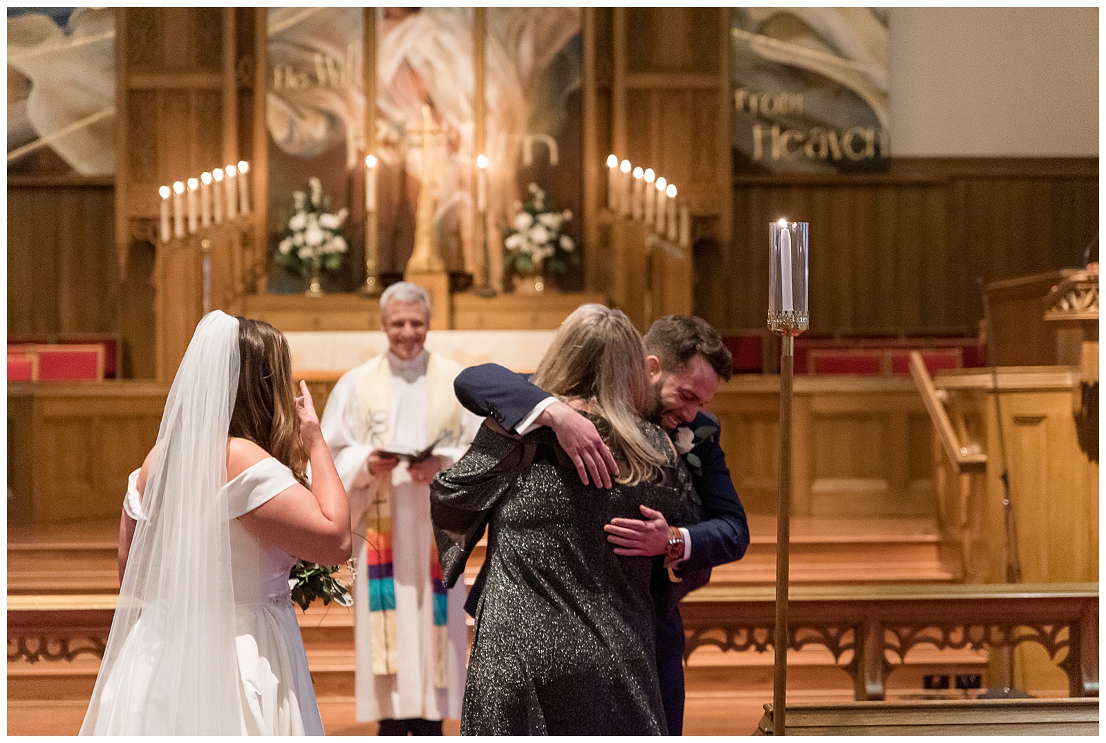 mother of the bride hugging groom during intimate wedding at gorgeous catholic church in lancaster pennsylvania