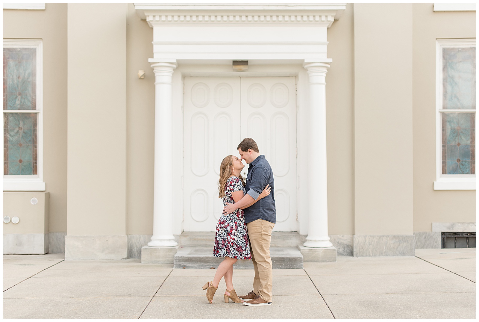 couple standing close almost kissing in front of tan historical building in lititz pennsylvania