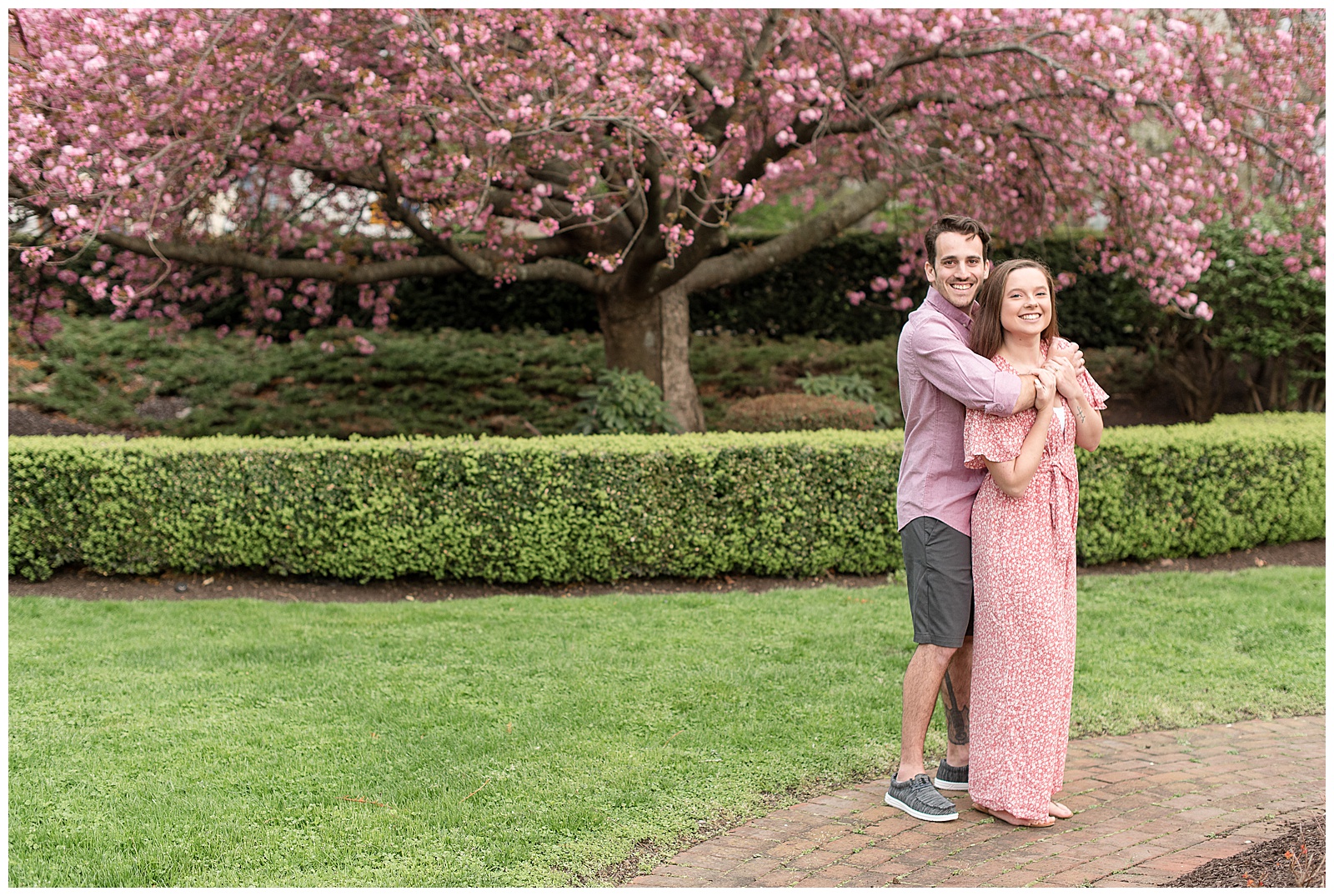 guy hugging girl on right side of photo standing along brick path and manicured lawn in harrisburg pennsylvania
