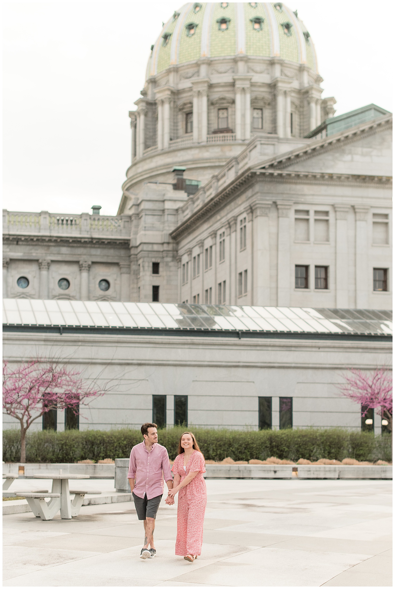 couple holding hands walking near harrisburg capitol building on bright spring evening