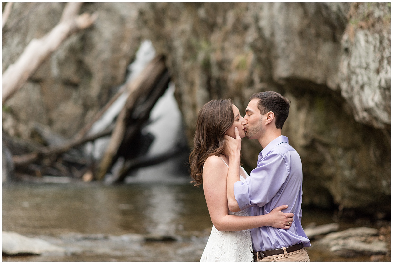 engaged couple kissing as guy gently holds girl's neck on overcast evening at rocks state park