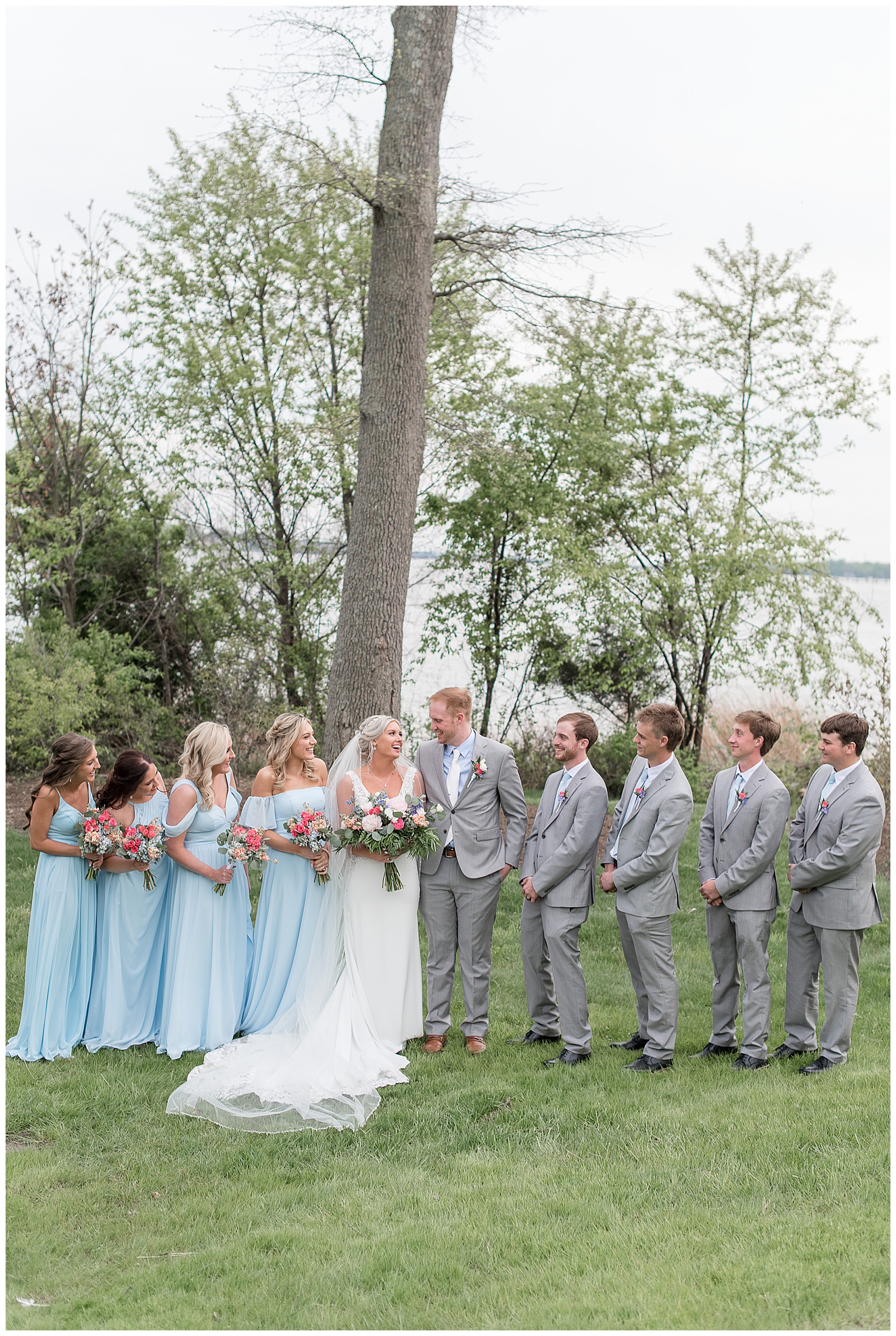 bride and groom looking at each other surrounded by bridal party outdoors on spring day in bel air maryland