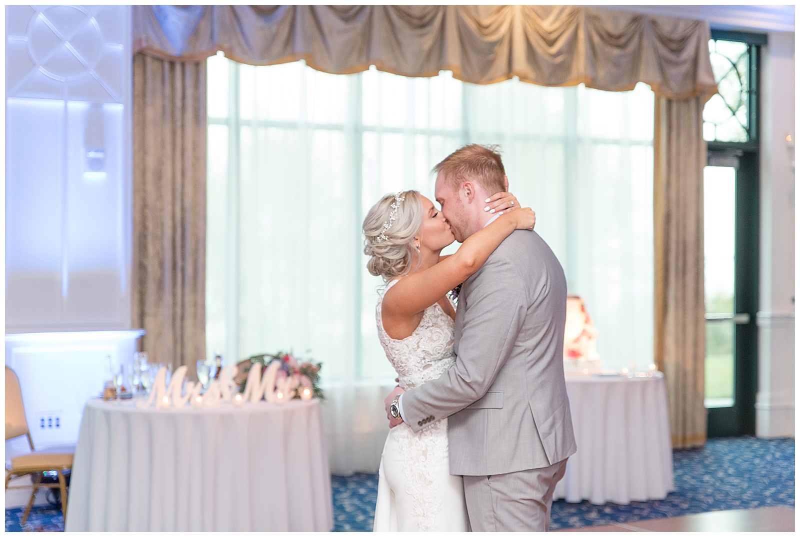 bride kissing groom on dance floor during reception at water's edge event center