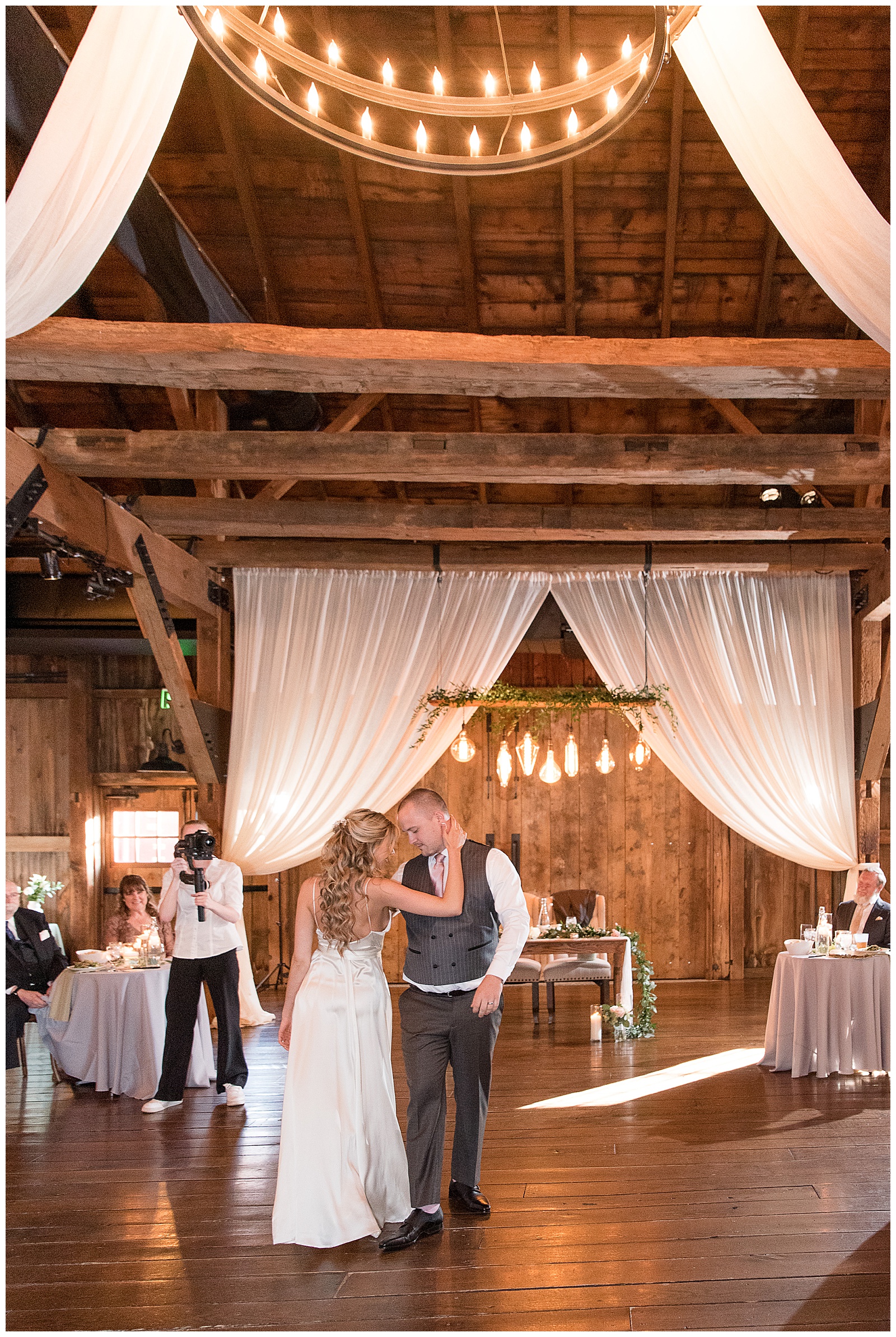 bride and groom having their first dance on barn dance floor as guests watch at the farm at eagles ridge