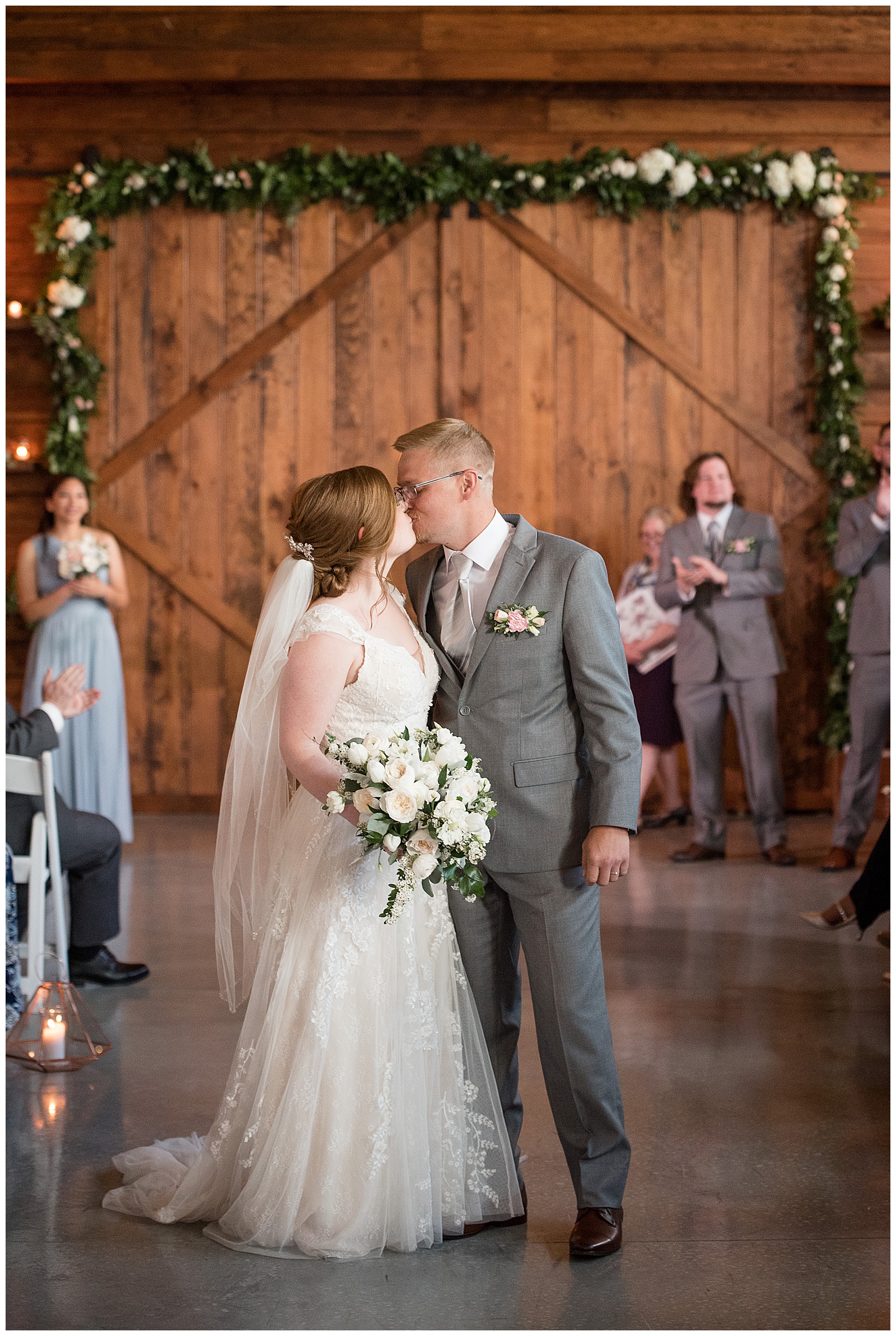 bride and groom kissing in center of dance floor inside barn reception at the barn at silverstone