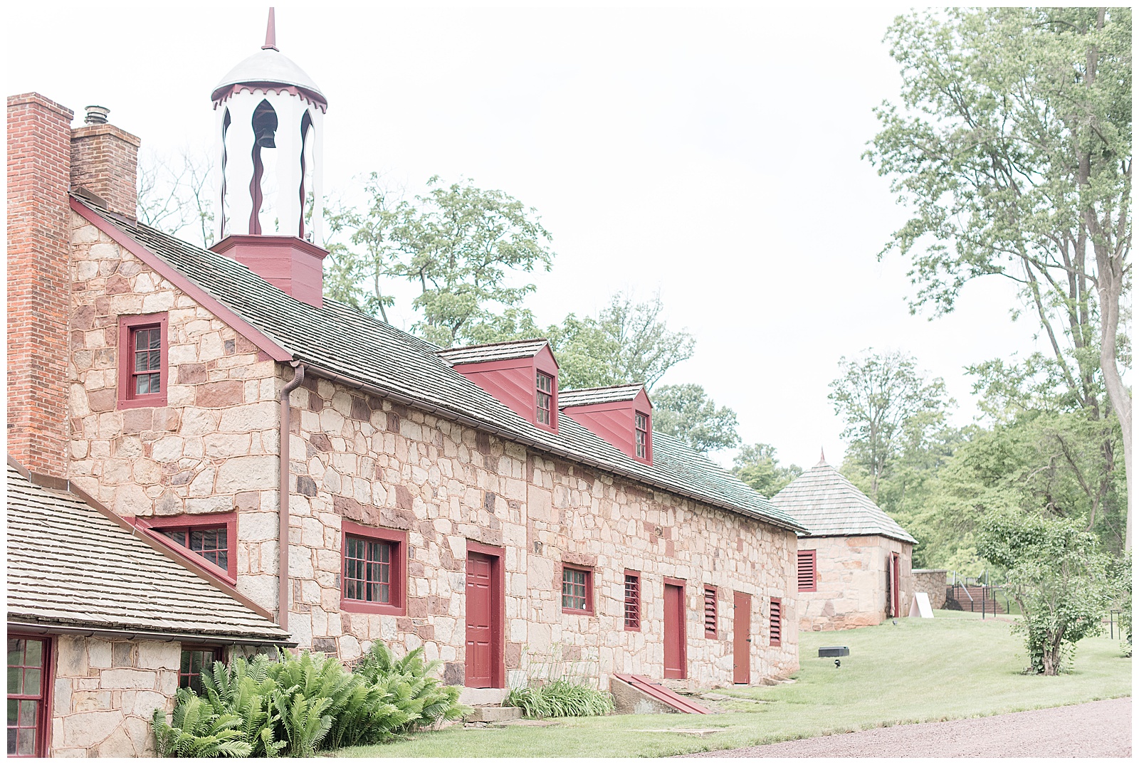 brown and white stone barn with white bell tower nestled onto elizabeth furnace property in lititz pennsylvania