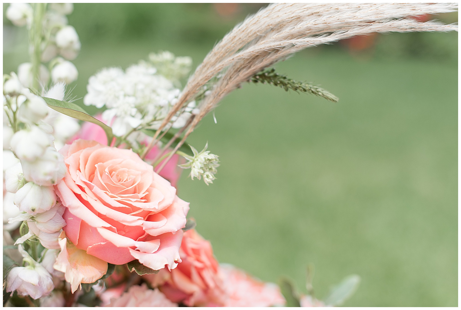 close up photo of coral and white flower arrangement with pampas grasses at elizabeth furnace in lititz pennsylvania