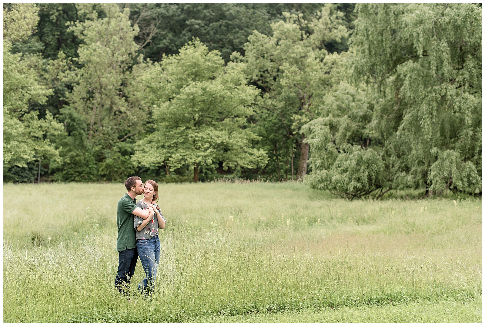 guy hugging and kissing girl at edge of grassy field at private residence in mechanicsburg, pennsylvania