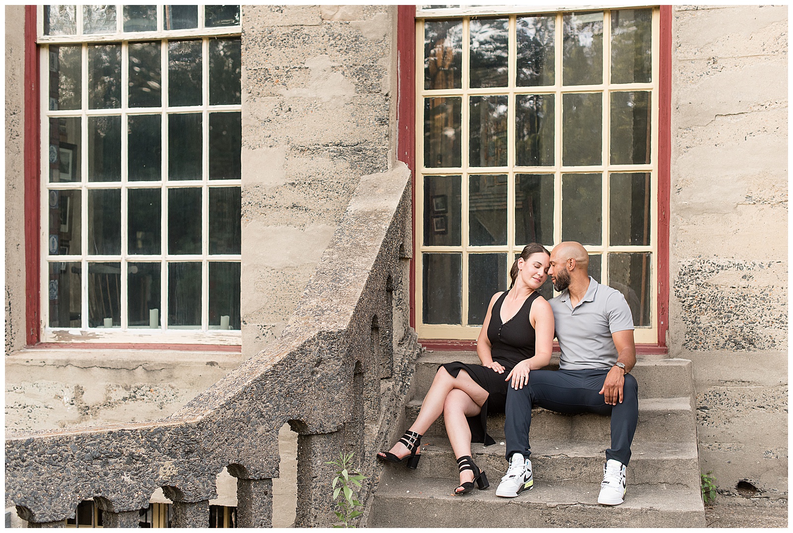 engaged couple resting foreheads together sitting on steps of fonthill castle in doylestown pennsylvania