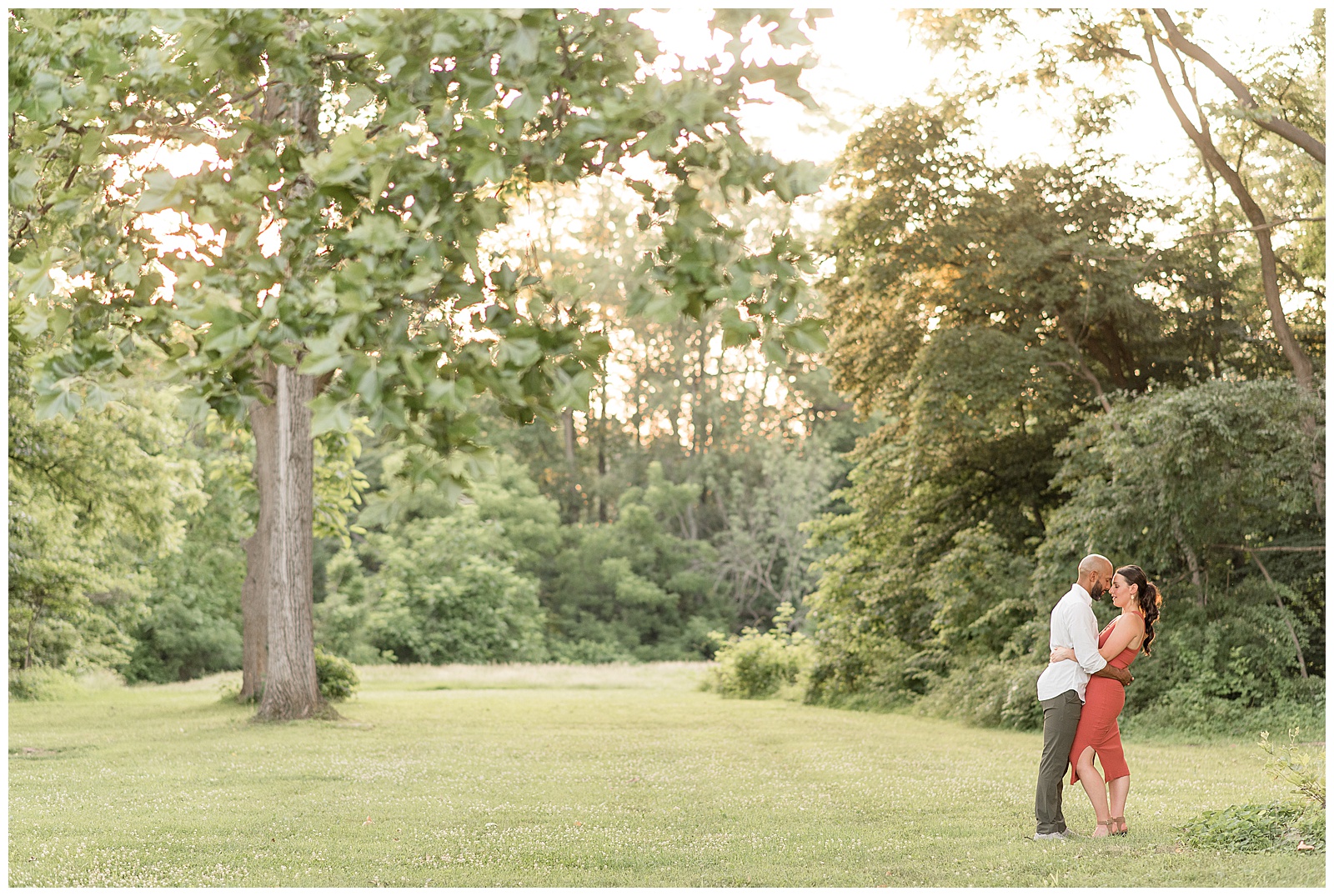 guy kisses girl on forehead on right side of photo with trees behind them in doylestown pennsylvania