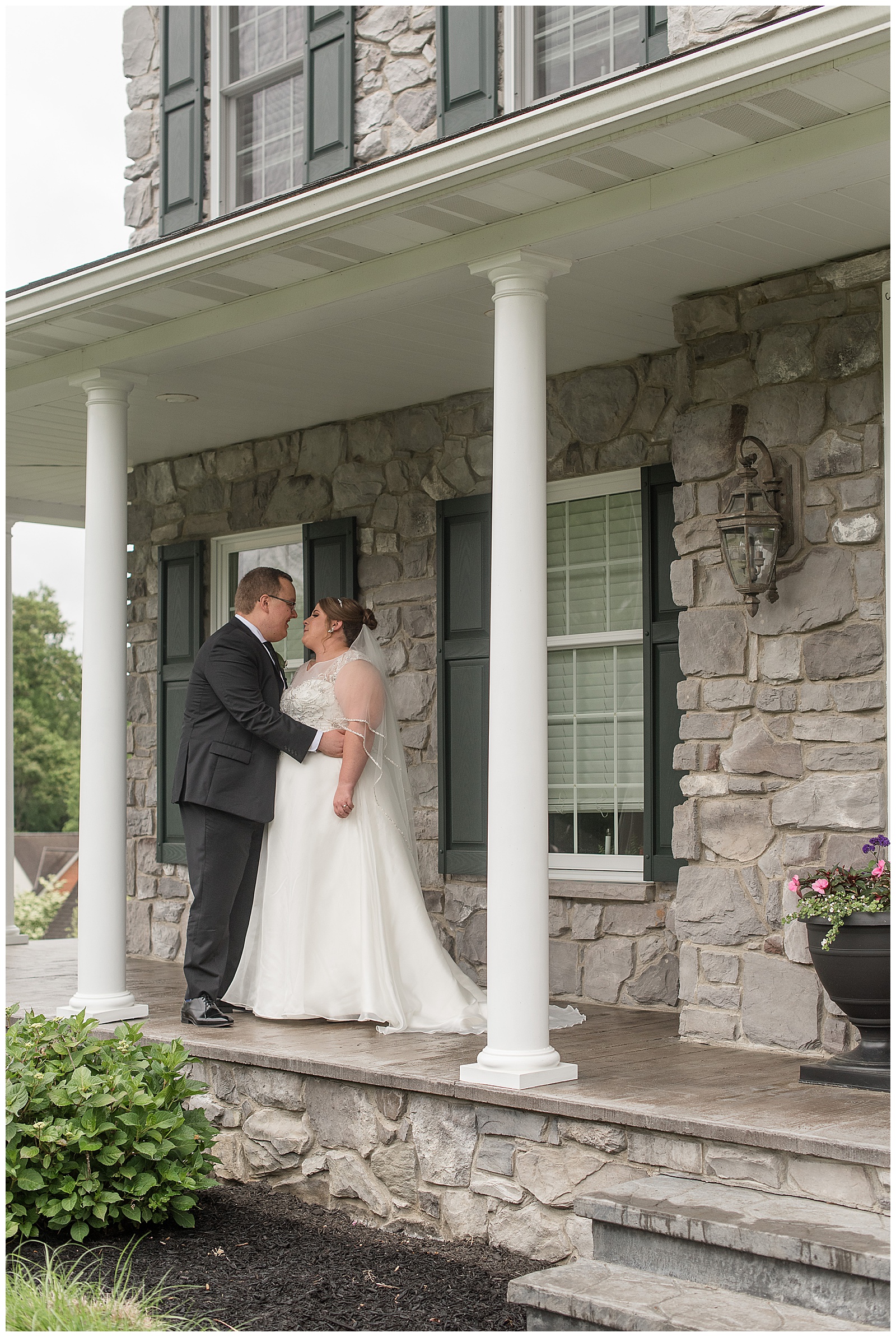 groom in black suit hugs his bride in sleeveless white wedding gown in lancaster pennsylvania