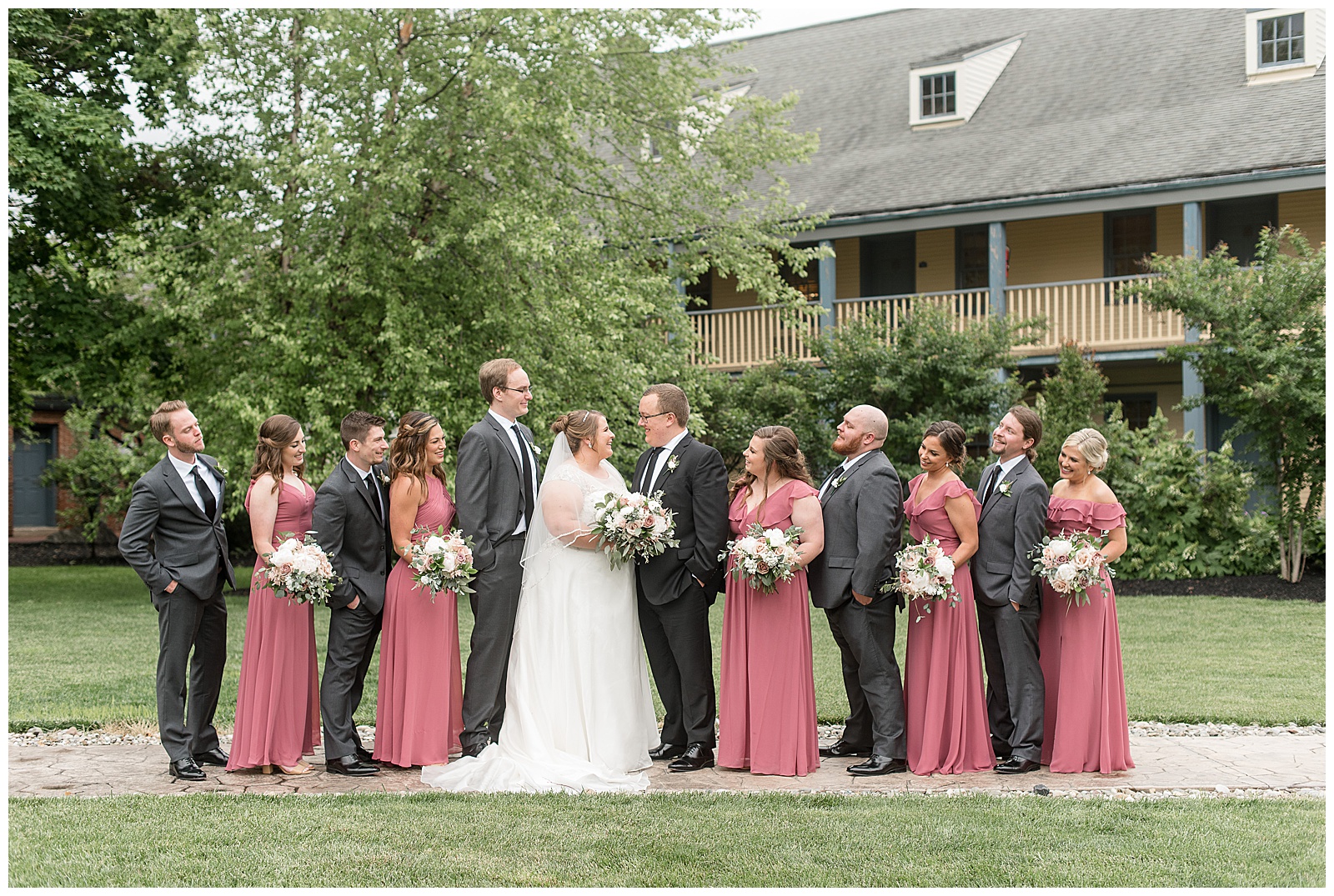 bride and groom surrounded by bridesmaids and groomsmen outside willows at historic strasburg wedding venue
