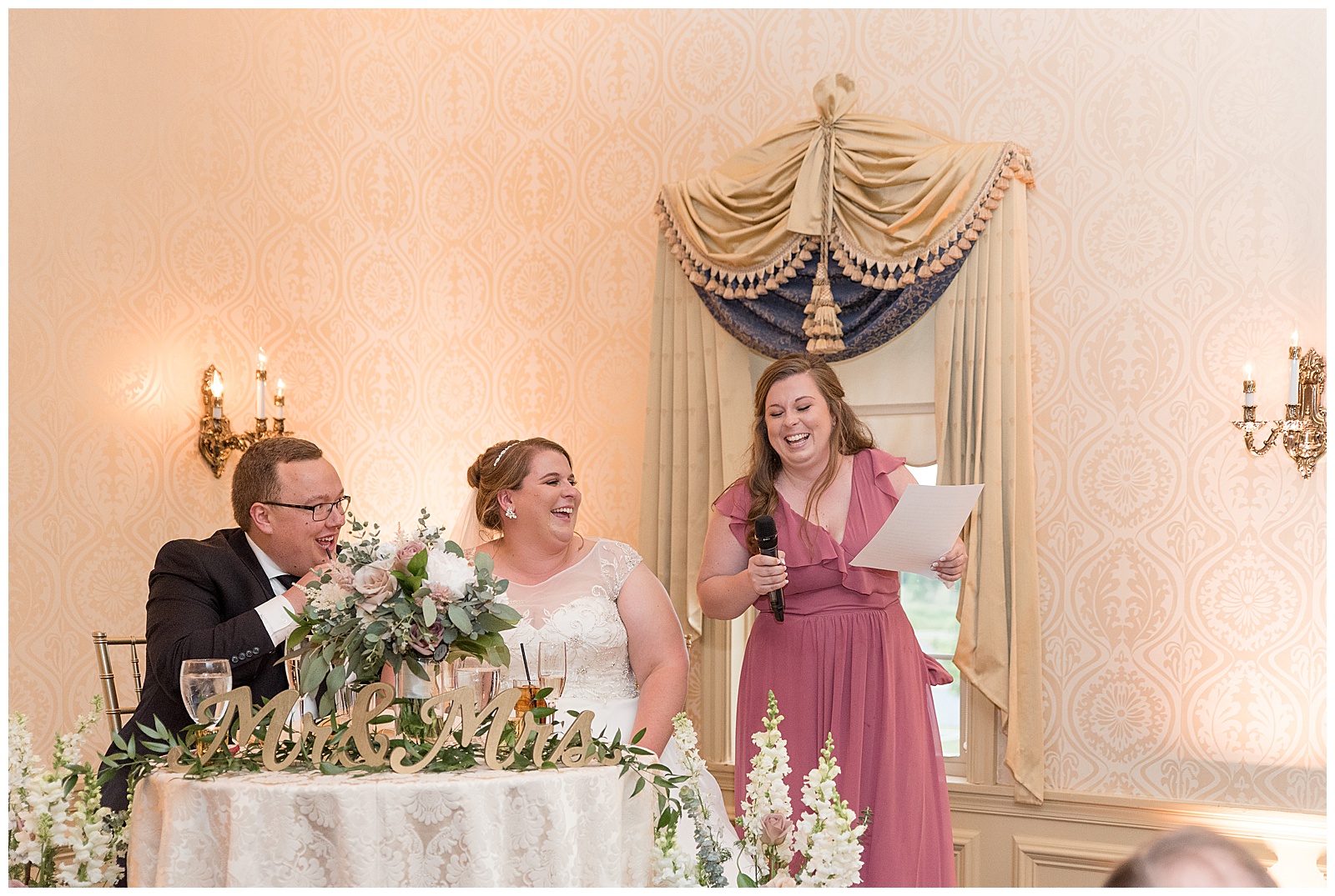 bride and groom laughing maid of honor tells funny story during her speech at wedding reception in lancaster pennsylvania