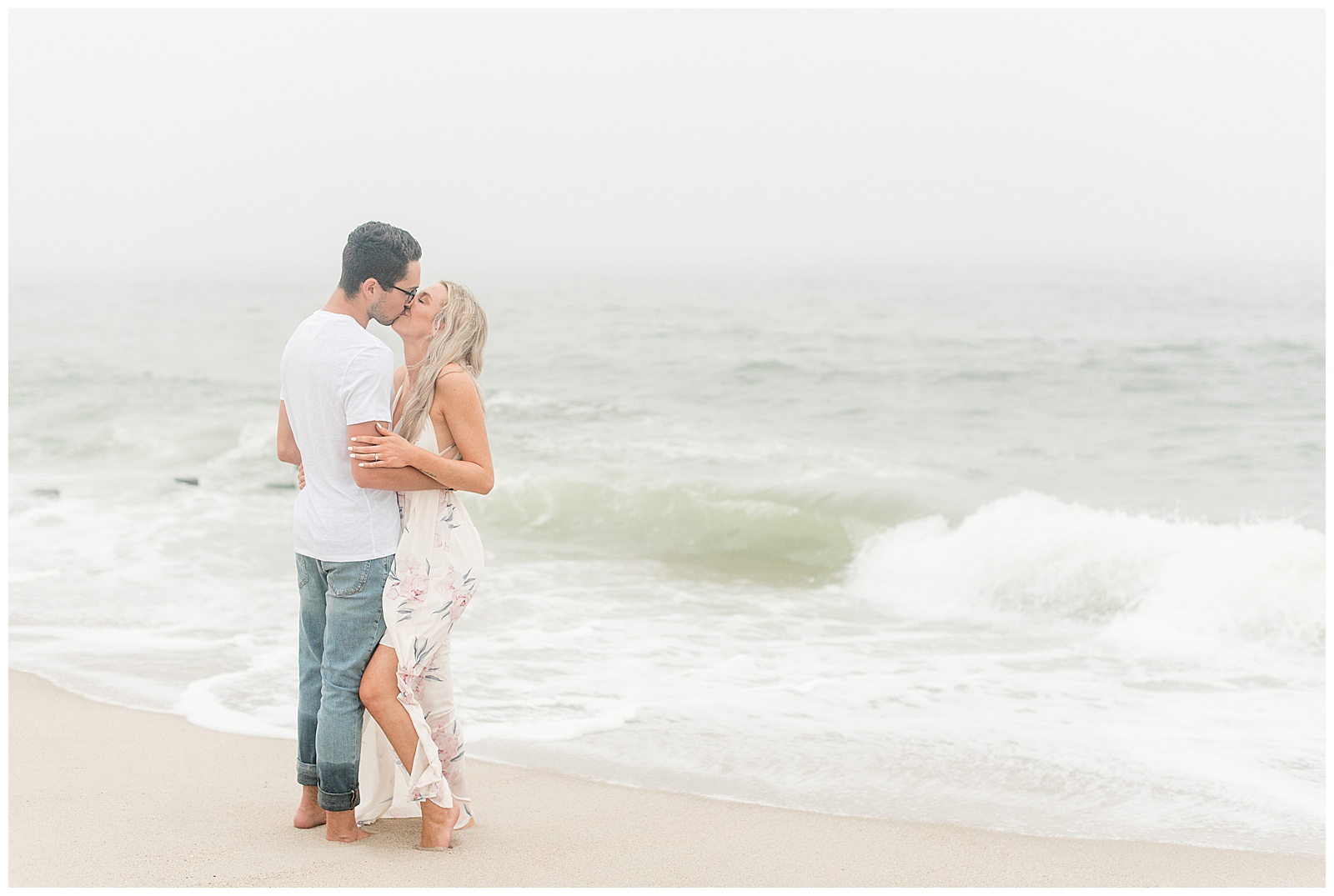 couple hugging tightly kissing along shoreline on foggy evening in bayhead new jersey