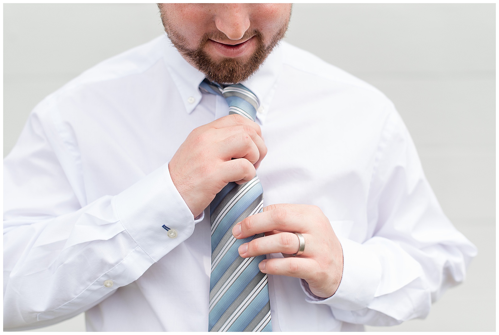 groom straightening light blue stripped tie