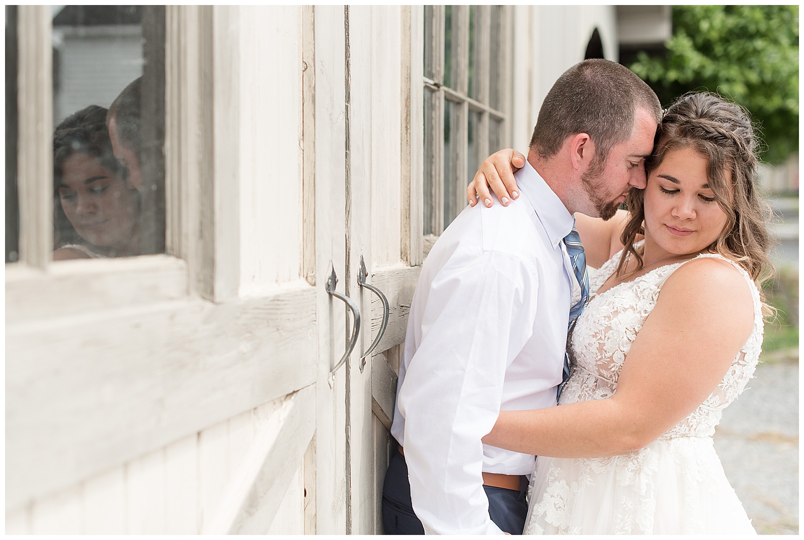 bride and groom portraits in front of white barn doors