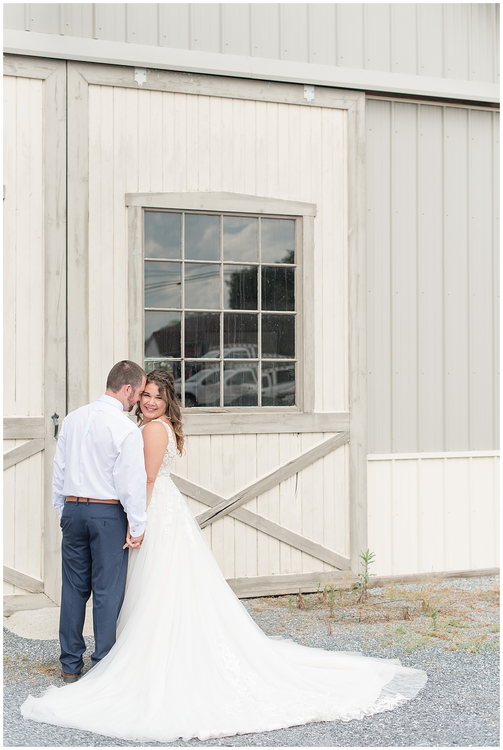 bride and groom portraits in front of white barn doors