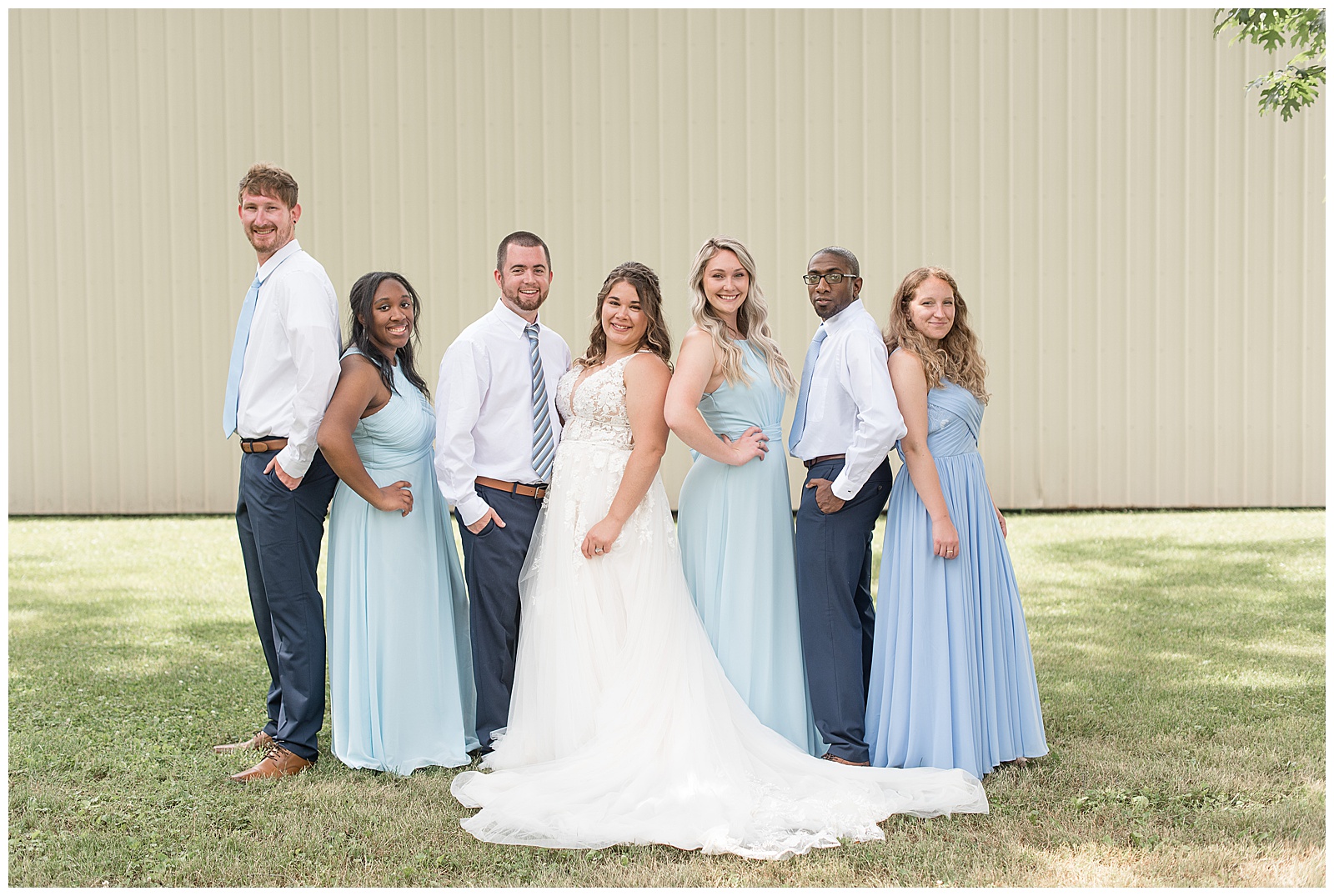 full bridal party in blue dresses smiling at camera