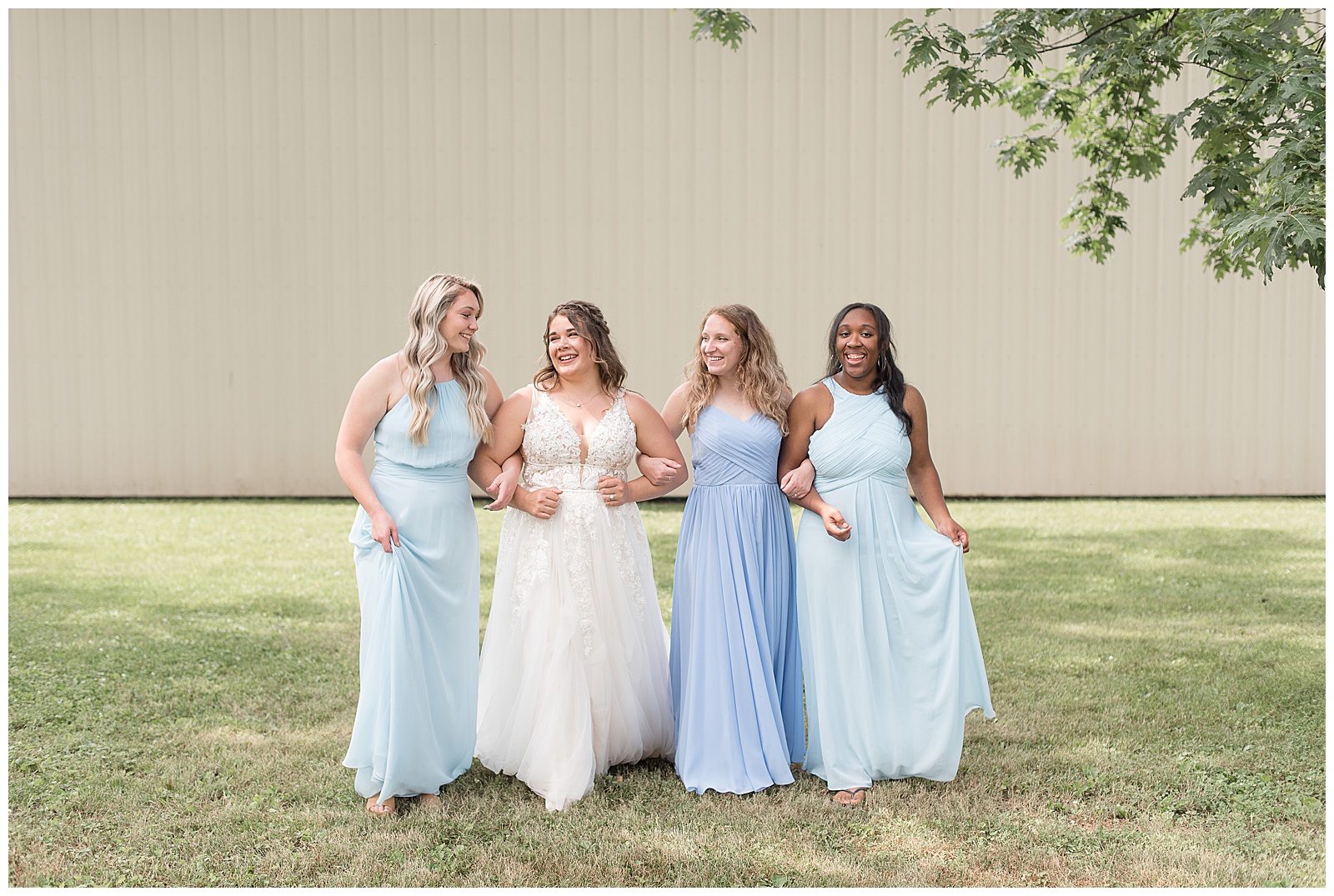bridesmaids with arms linked walking and laughing together