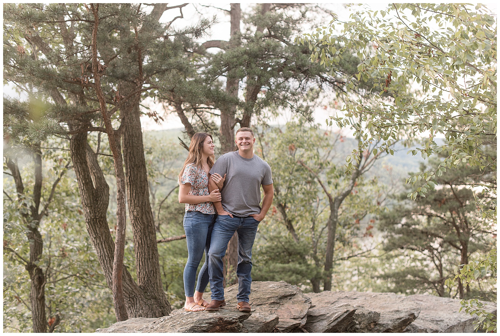 woman smiling at her man as he smiles at the camera and she hugs his right arm at pinnacle overlook