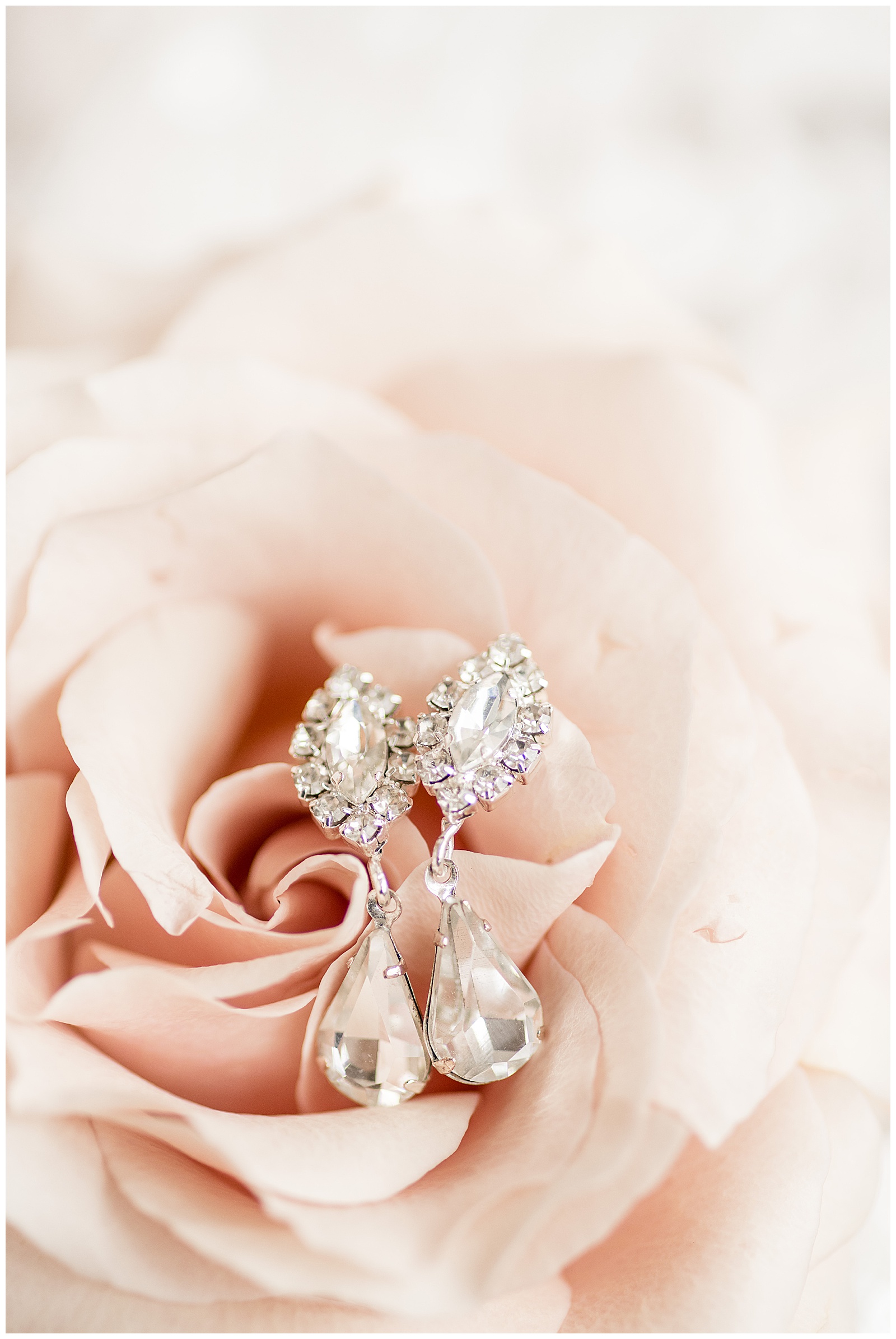 diamond earrings displayed inside light pink rose for wedding at Antrim 1844 in maryland