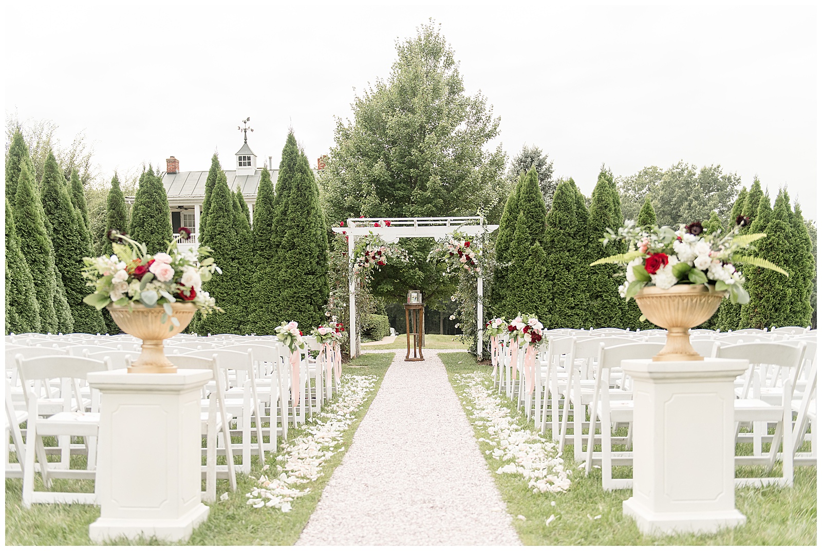 outdoor wedding area with rows of white chairs and beautiful white archway on wedding day at Antrim 1844 in Maryland