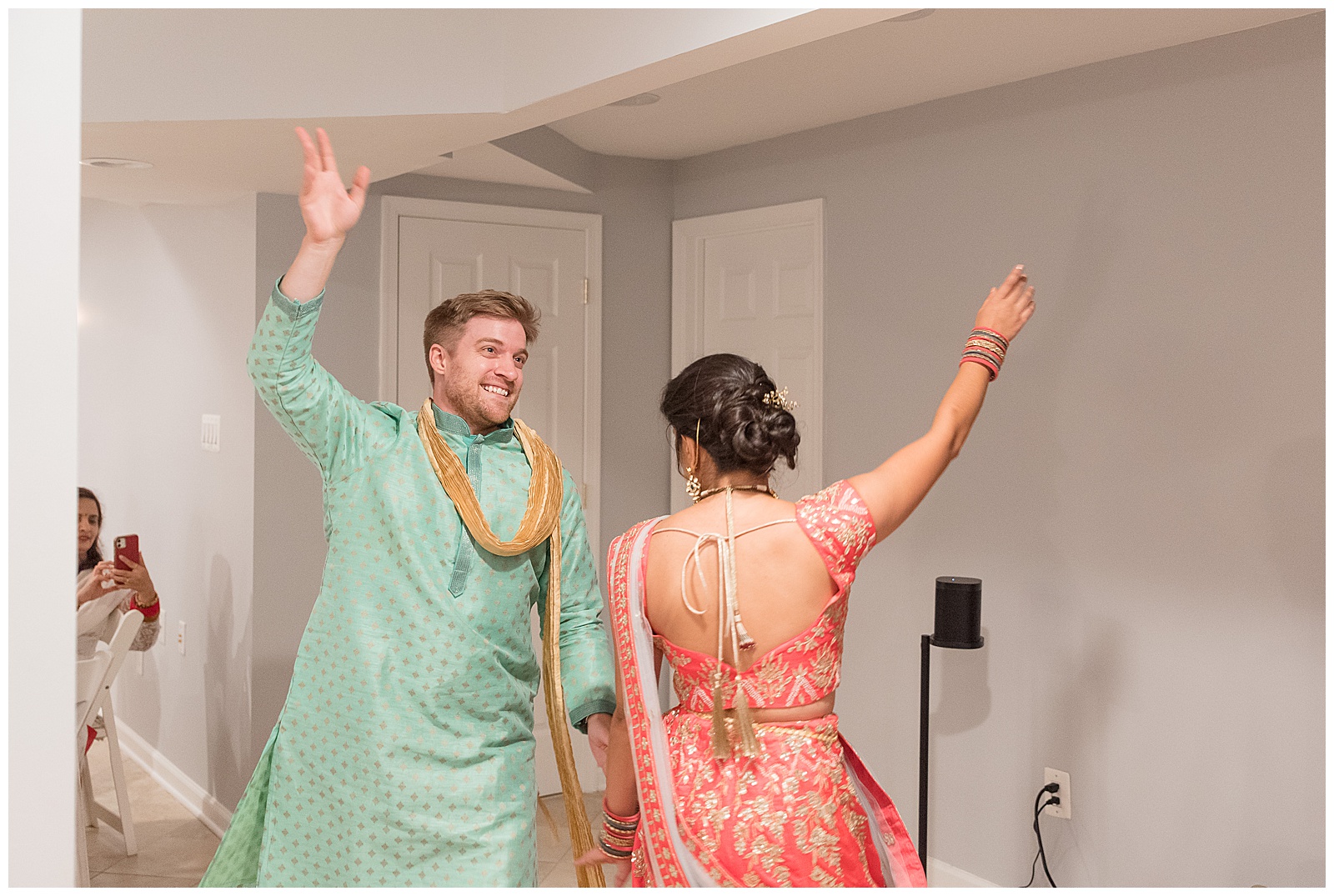 traditional indian wedding dance with groom in light green outfit and bride in dark pink dress in ellicott city maryland