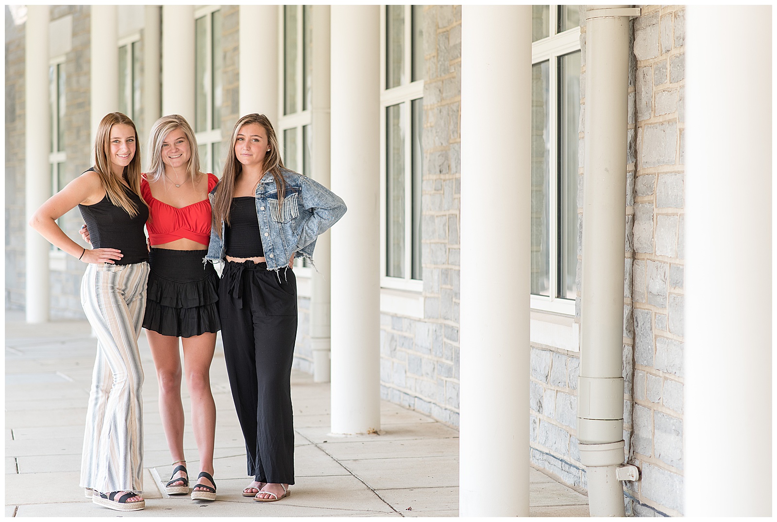 three senior girls standing close with their arms wrapped around each others' backs at founders hall in hershey pennsylvania