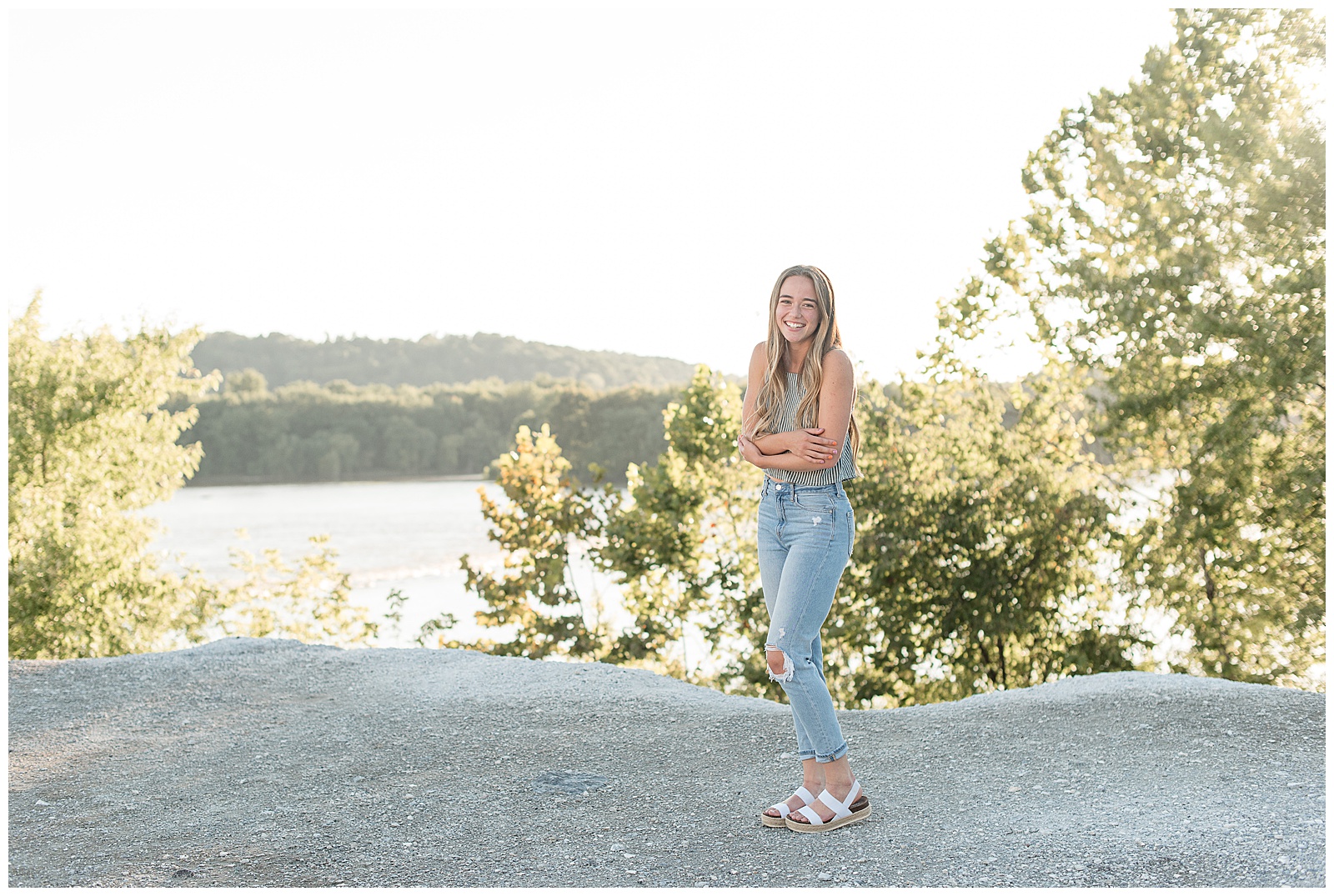 senior girl wearing sage green tank top and blue jeans standing atop the white cliffs of canoy in lancaster pennsylvania