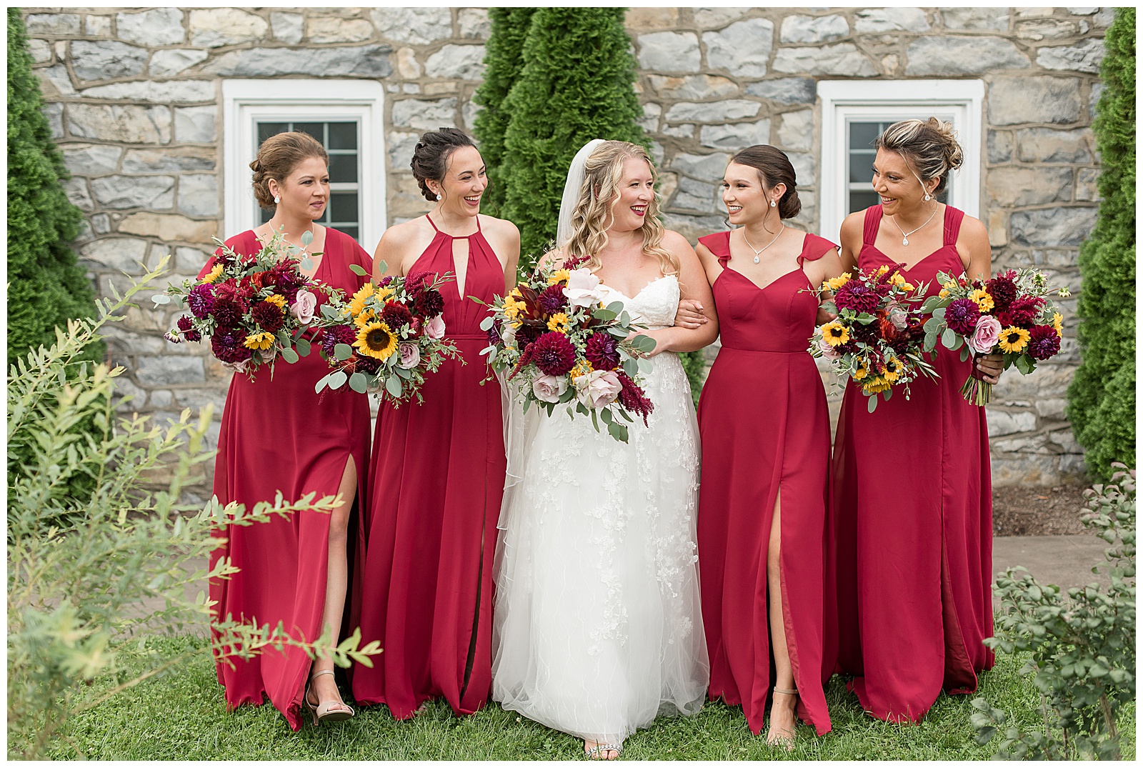 bride with her four bridesmaids all walking toward camera and smiling and looking at each other at the barn at silverstone