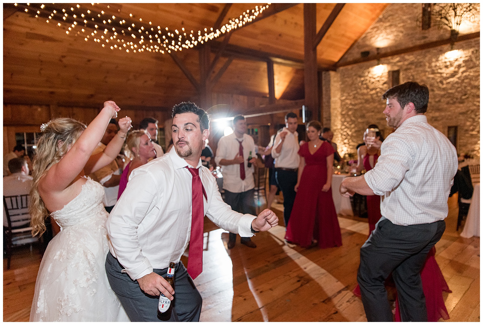 groom and bride dancing the night away during reception along with their guests at the barn at silverstone