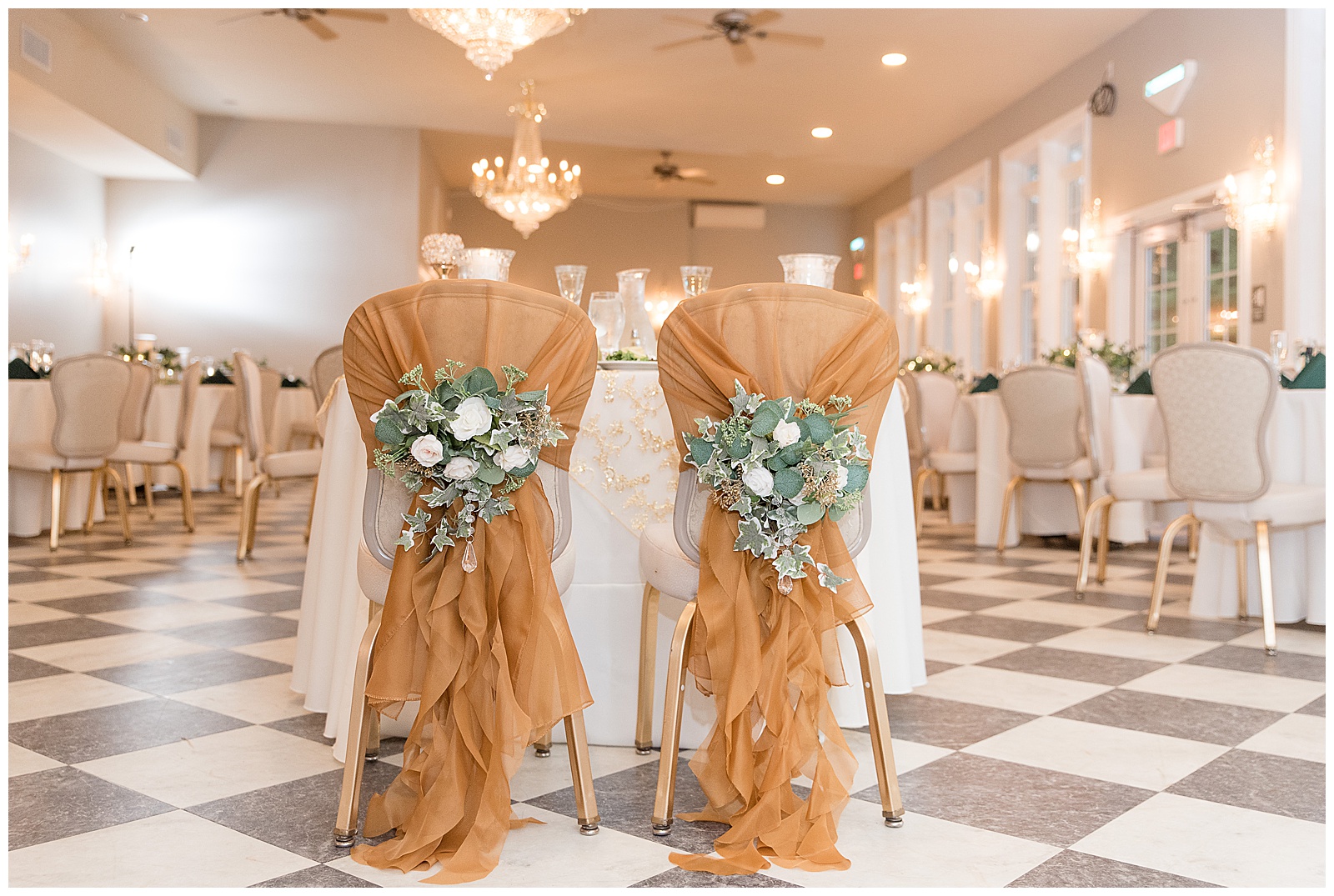 beautifully decorated chairs for the bride and groom to sit on at wedding reception wrapped in golden fabric with fresh flower bouquets attached