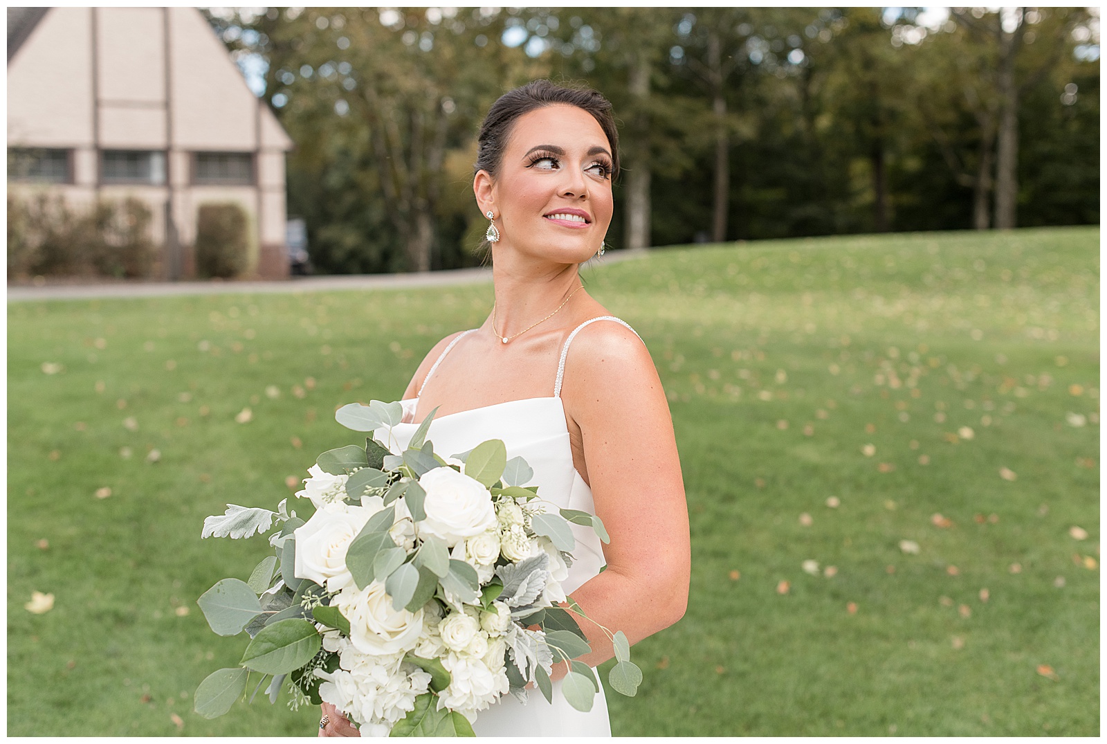 bride looking back over her left shoulder and eyes towards the sky holding bouquet at north jersey country club