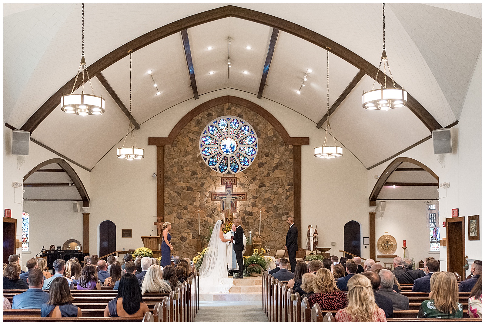 bride and groom holding hands at the altar inside beautiful catholic church wedding ceremony in northern new jersey