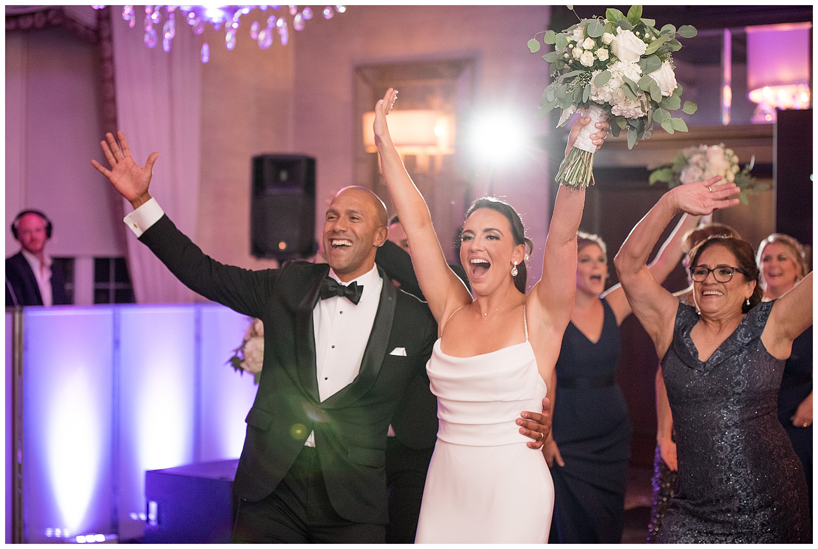 bride and groom celebrating with arms high to the sky and huge smiles as they enter reception at north jersey country club