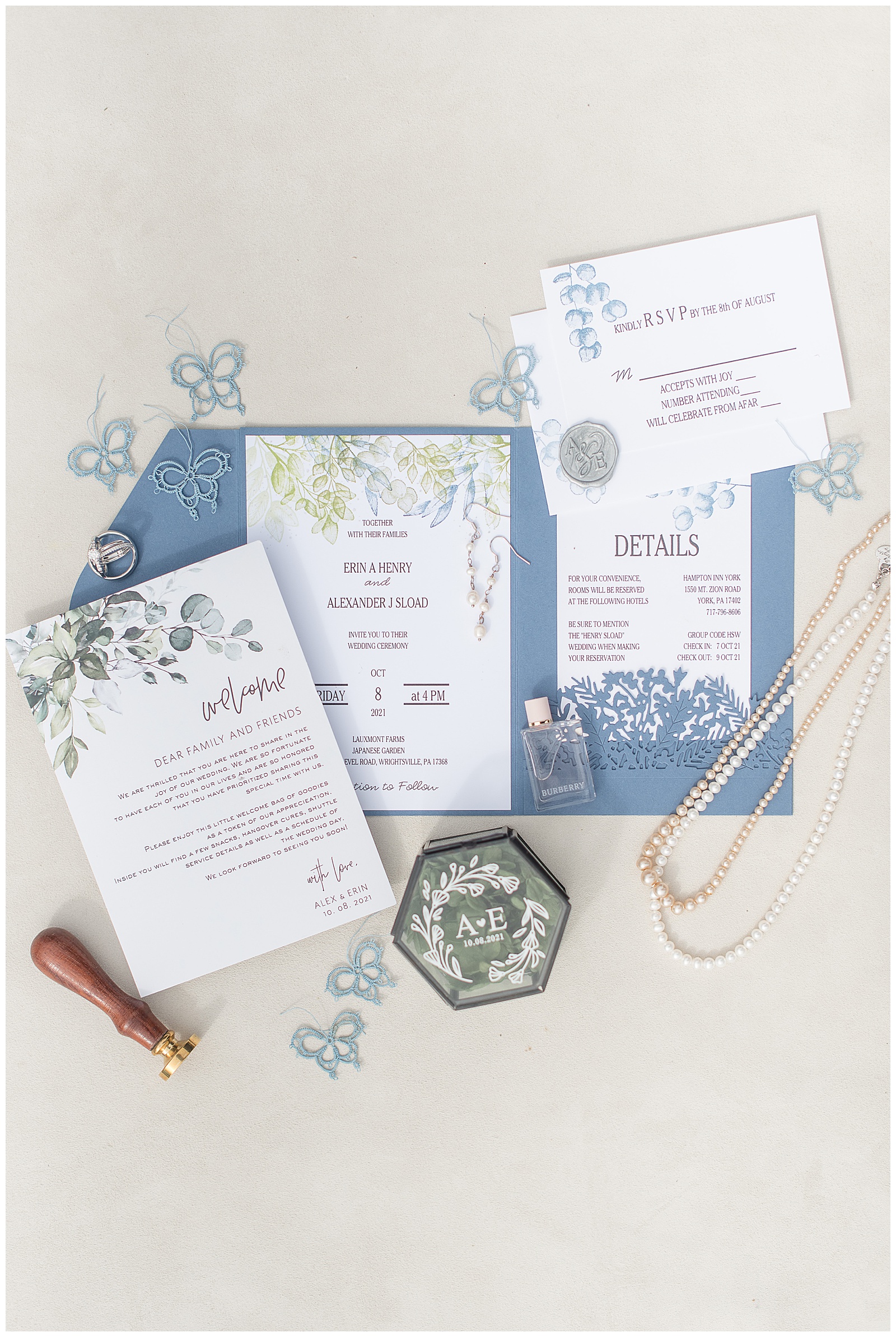wedding invitation displayed by pearl necklaces, ring box, and other details at york pennsylvania wedding