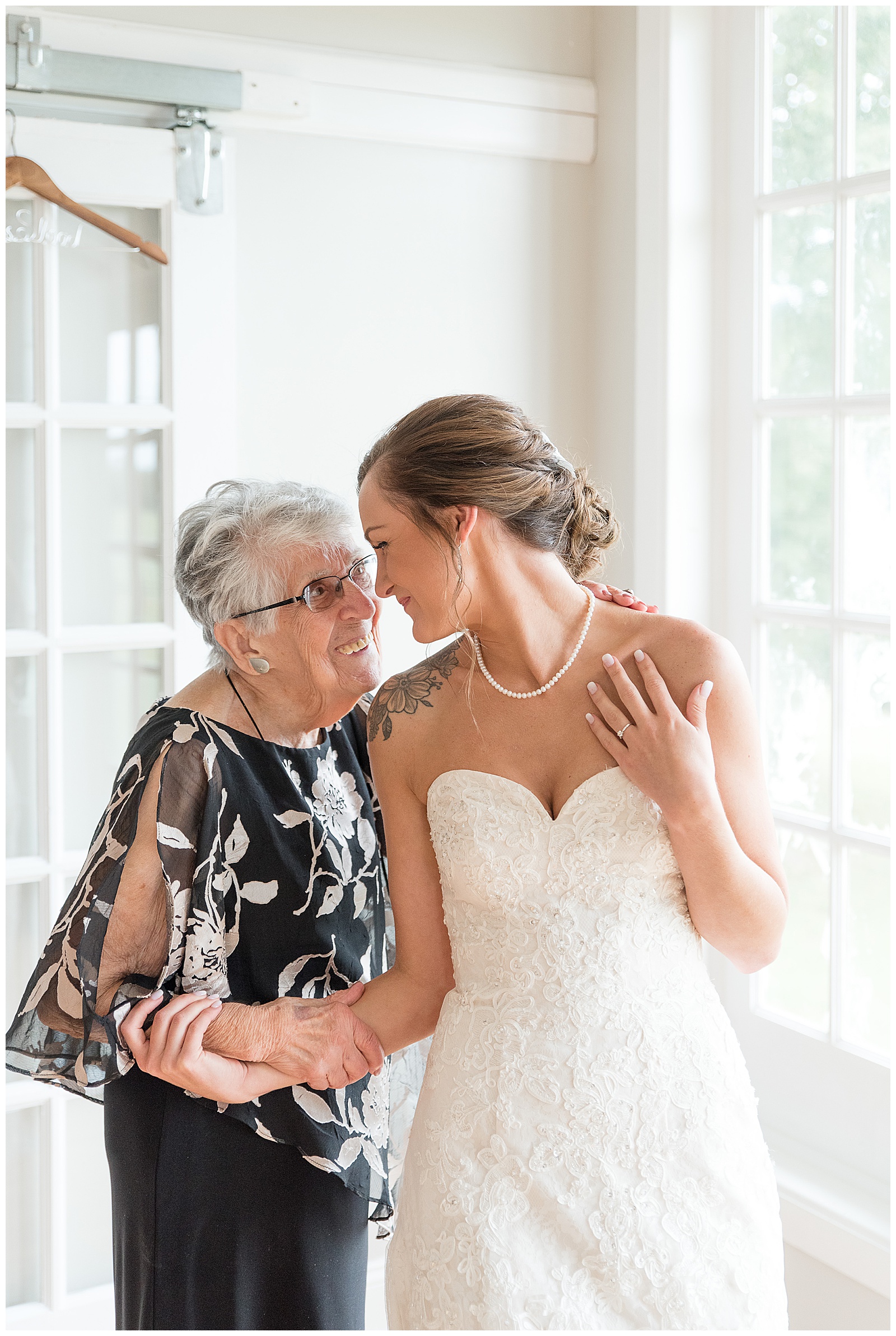 bride sharing special moment with her grandmother in bridal suite as they smile and hold hands at lauxmont farms