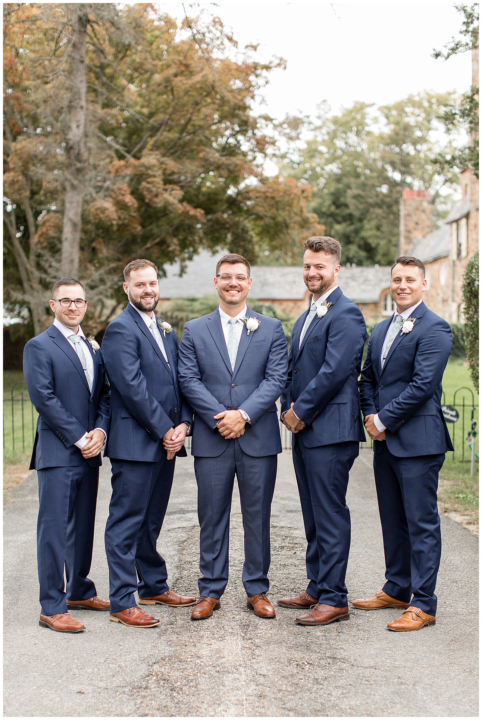 groom smiling with his four groomsmen around him standing outdoors at lauxmont farms in york pennsylvania